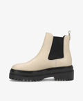 Beige Chelsea-støvle fra phenumb copenhagen med sort elastikpanel og kraftig sort sål.